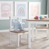 A child's play table and chairs set with decorative artwork on the wall and plush toys on the furniture. Produktbild-Vorschau