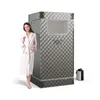 A woman in a bathrobe stands next to a portable steam sauna. Anteprima dell’immagine prodotto