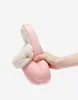 Rosa Hausschuh mit flauschigem beigem Riemen und kleinem Knopf, in der Hand gehalten Produktbild-Vorschau