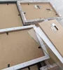 Close-up view of the backs of several picture frames, showing the backing boards, glass, and hanging mechanisms. Produktbild-Vorschau