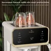 A close-up of a coffee machine with two glass cups warming on top. Voir les images du produit