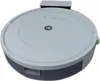 A white and gray robot vacuum cleaner is shown from a slightly elevated angle, with its charging dock visible in the background. Náhľad obrázku produktu