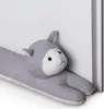 A stuffed animal shaped like a cat is leaning against a white wall. Náhľad obrázku produktu