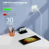 A desk setup showing a smartphone charging wirelessly, a charger plugged into a wall, and office supplies. Produktbild-Vorschau