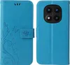A blue flip phone case with a floral and butterfly design is shown open, displaying the interior and the exterior with the phone camera cutout. Produktbild-Vorschau