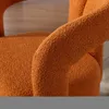 A close-up view of the textured fabric of an orange armchair. Voir les images du produit