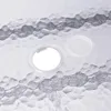 Close-up view of a glass table surface with two circular inserts. One insert is a clear hole, and the other is a clear plastic cap. Produktbild-Vorschau