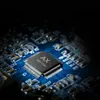 A close-up shot of a computer chip on a blue circuit board. Voir les images du produit