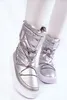 A close-up shot of a pair of silver snow boots worn by a person. Produktbild-Vorschau
