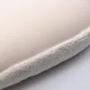 A close-up view of the edge of a cream-colored pillow with a fuzzy light gray trim. Produktbild-Vorschau