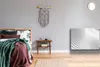 A bedroom with a bed, nightstand, and wall decor. Produktbild-Vorschau