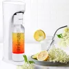 A white water carbonator with a bottle of sparkling water, a glass of water with a straw, lemons, and flowers. Podgląd zdjęcia produktu