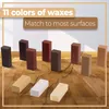A collection of wax repair sticks for furniture and flooring, displayed on a wooden surface. Voir les images du produit