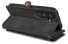 A black leather wallet-style phone case with a phone inside, viewed from the back. Produktbild-Vorschau