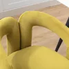 Close-up view of the armrests and seat of a yellow velvet chair. Voir les images du produit