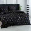 A bed with black bedding featuring a gold heart pattern. Produktbild-Vorschau