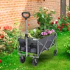 A gray folding wagon filled with plants sits on a grassy lawn in front of a brick wall and a flower garden. Produktbild-Vorschau