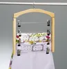 A wooden hanger with multiple bars and clips holding skirts or pants, hanging on a clothing rack. Náhled obrázku produktu