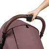 A hand is shown gripping the handle of a stroller. Produktbild-Vorschau