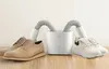 A shoe dryer with two hoses connected to a pair of dress shoes and a pair of sneakers. Produktbild-Vorschau