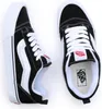 A top-down view of a pair of black and white Vans sneakers. Anteprima dell’immagine prodotto