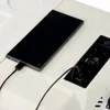 A smartphone is charging next to a portable cooler with a digital display. Náhled obrázku produktu