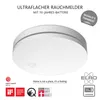 A white, ultra-thin smoke detector is shown from a slightly elevated front-side angle, with marketing text and logos surrounding it. Produktbild-Vorschau