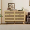 A wooden dresser with cane-woven drawer fronts sits in a living room setting.