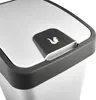 A close-up view of the lid of a trash can, showing the lid's opening mechanism and a logo. Podgląd zdjęcia produktu
