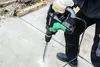 A person is using a rotary hammer drill to drill into concrete. Produktbild-Vorschau