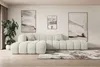 A modern living room with a large sectional sofa, abstract art on the wall, and a potted plant.