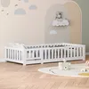 A child's bed with a safety rail in a nursery with cloud-themed wall decorations. Anteprima dell’immagine prodotto