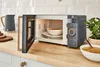 A modern kitchen counter with a microwave, kettle, and bowl of soup. Náhled obrázku produktu