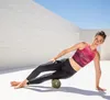 A woman is using a foam roller on her leg outdoors. Anteprima dell’immagine prodotto