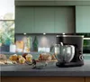 A black stand mixer is displayed on a countertop with various baked goods in front of it. Náhľad obrázku produktu