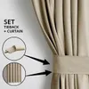 A close-up of a beige curtain with a tieback, showing how it is used to hold the curtain in place. Produktbild-Vorschau