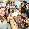 A group of friends enjoying a barbecue on a rooftop. Produktbild-Vorschau