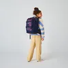 A young girl wearing a backpack and a striped sweater, viewed from the side. Anteprima dell’immagine prodotto