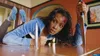 A woman is lying on a table with a knife in her hand and blood on her head. Produktbild-Vorschau