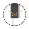 A modern, minimalist wall clock with a black face and wooden hands, set against a white background. Produktbild-Vorschau