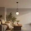 A modern living room with a sofa, coffee table, plants, and a pendant light. Náhled obrázku produktu