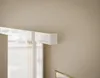 A close-up view of a white, glossy sliding door with gold accents, mounted on a beige wall. Produktbild-Vorschau