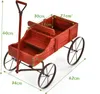 A red wooden wagon with metal wheels, shown from a diagonal angle with dimensions indicated by text overlays. Podgląd zdjęcia produktu