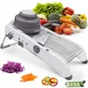 A white mandoline slicer is displayed prominently in the foreground, with a variety of fresh vegetables arranged in the background and around the slicer. Sliced vegetables are also shown in the foreground. Produktbild-Vorschau