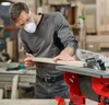 A man is using a table saw in a workshop. Náhľad obrázku produktu