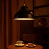 A dimly lit cafe setting with a pendant lamp, a cup of coffee, and a slice of cake on a table. Produktbild-Vorschau