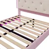 Close-up view of the slatted base of a pink bed frame with a beige tufted headboard. Podgląd zdjęcia produktu