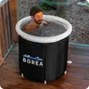 A man is sitting in a portable ice bath on a wooden deck. Produktbild-Vorschau