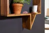 A close-up view of a wooden shelf with a potted plant and stacked bowls. Produktbild-Vorschau