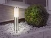A modern outdoor lamp stands in a garden bed with gravel and a bush. Anteprima dell’immagine prodotto